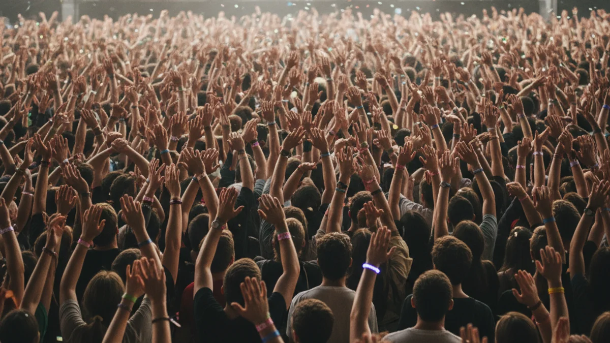 Imagen genérica de una multitud asistiendo a un concierto, con las manos levantadas, sin rostros reconocibles.