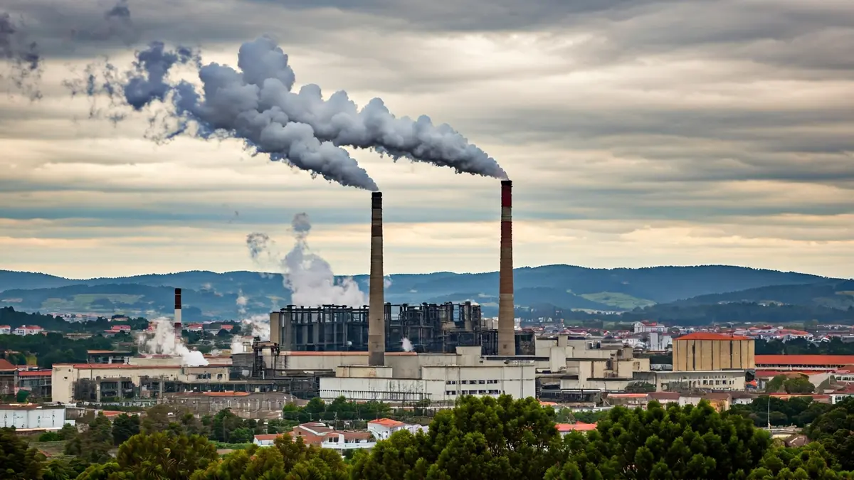Imagen de un paisaje industrial con chimeneas emitiendo humo.