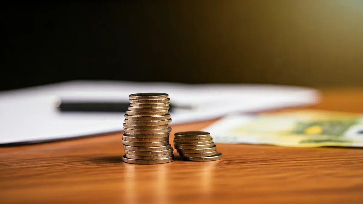 Imagen genérica de monedas y billetes de euro sobre una mesa, simbolizando beneficios financieros.