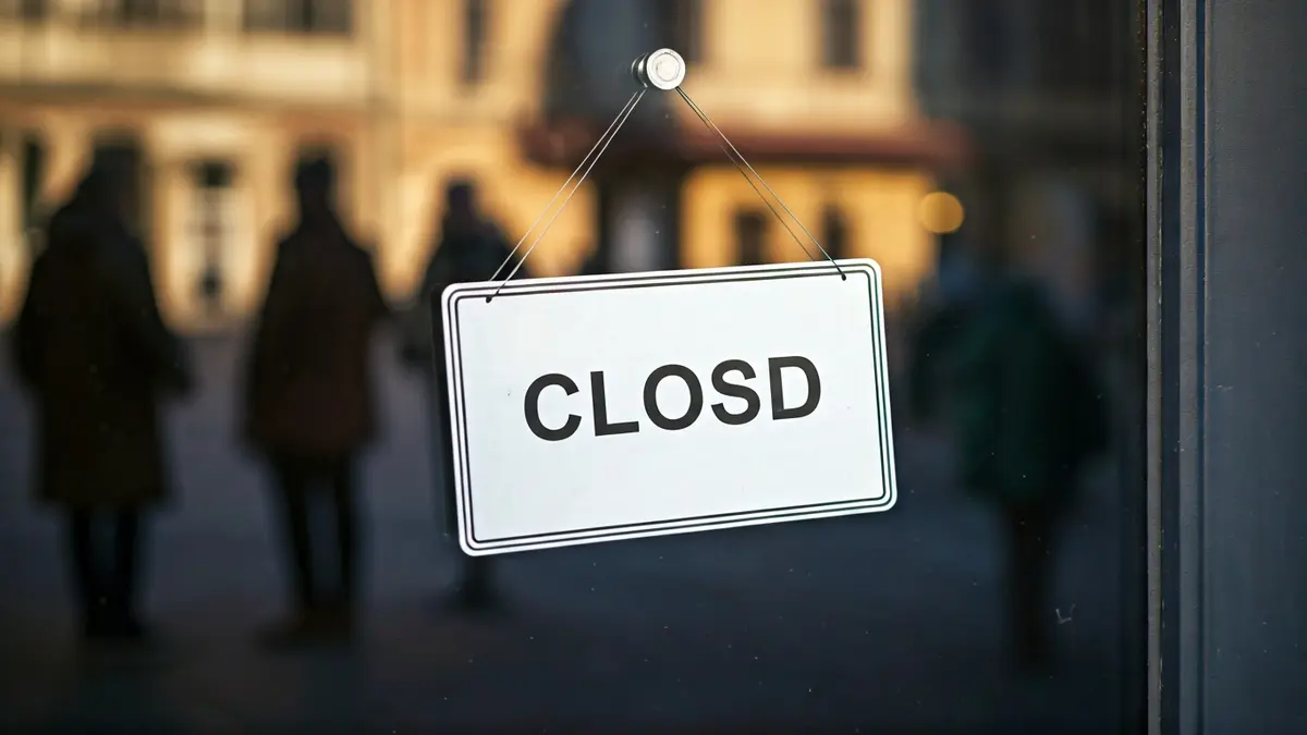 Closed sign on a local business, reflecting the street.