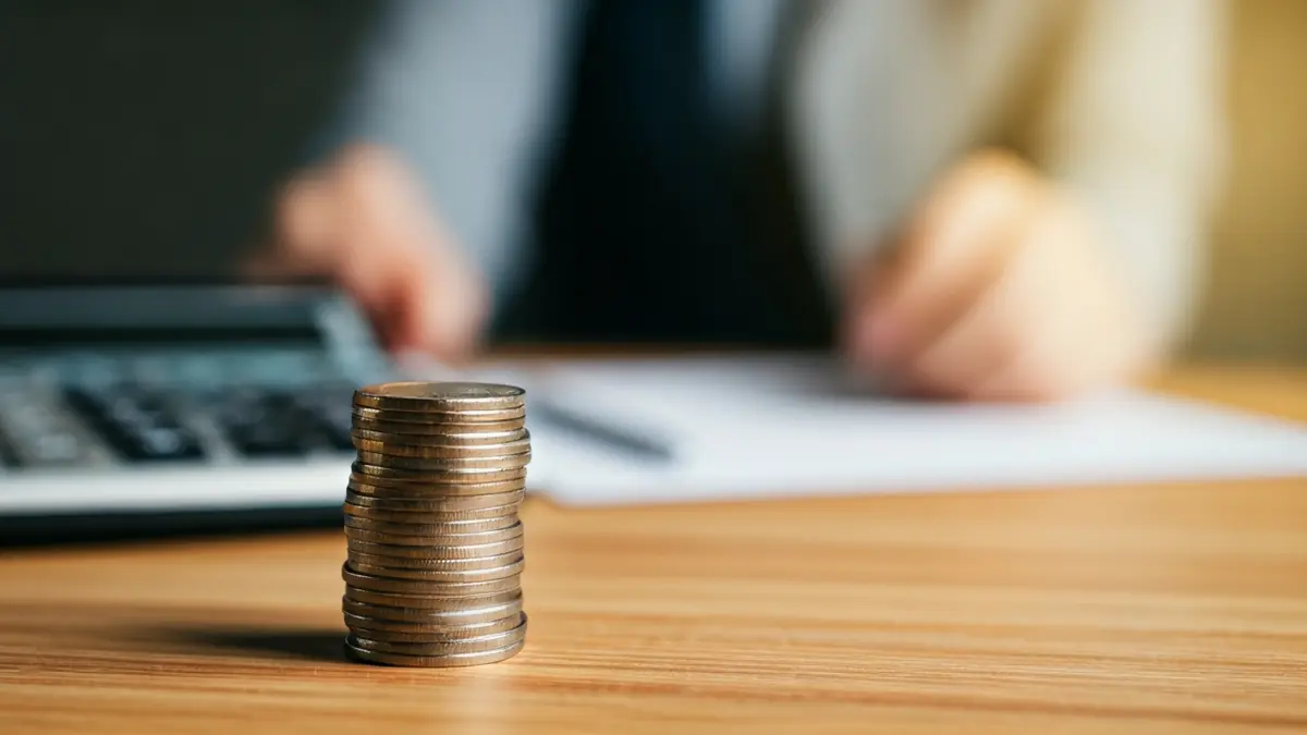 Imagen genérica de monedas y billetes de euro sobre una mesa, simbolizando deuda y problemas financieros.