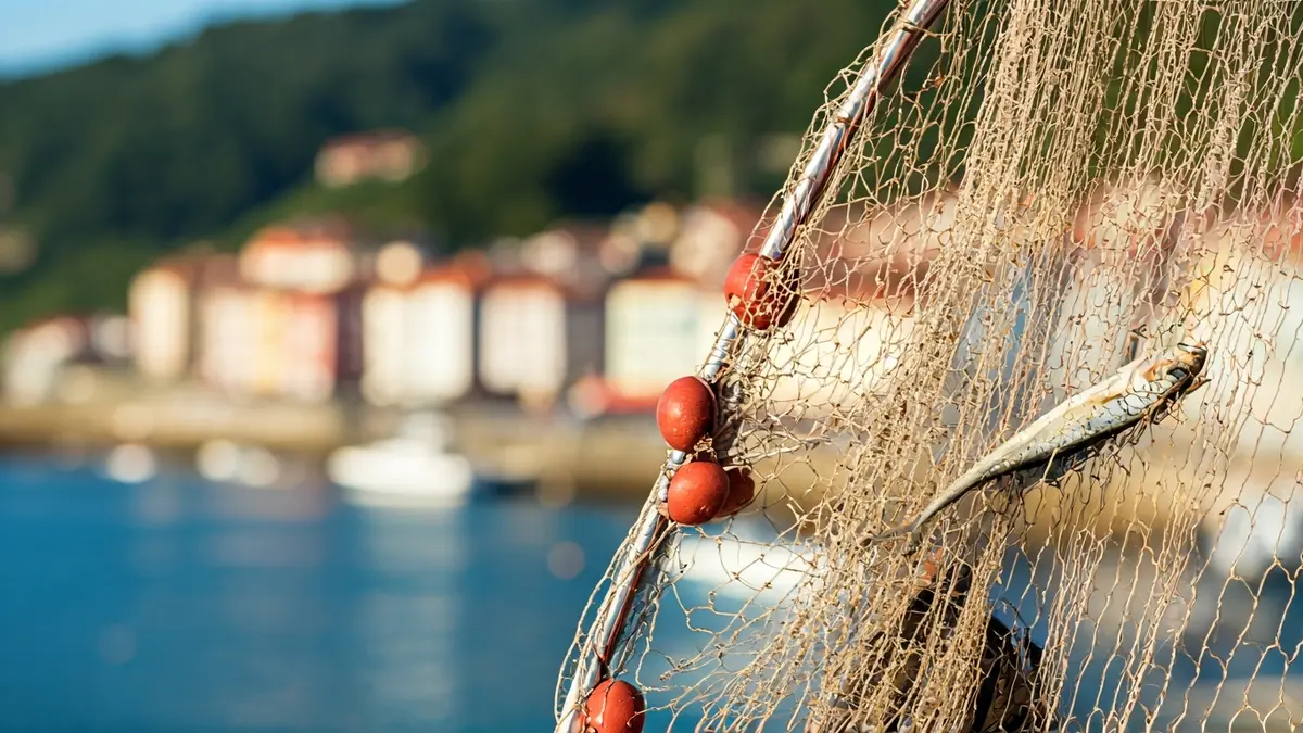 Imagen genérica de una red de pesca con un fondo difuminado de un pueblo costero vasco.