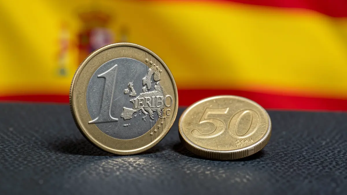 Imagen genérica de monedas de euro sobre un fondo difuminado de la bandera española.