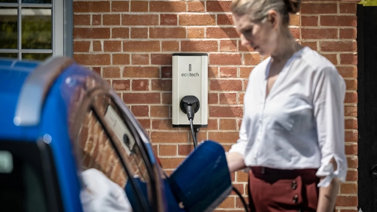 Coche eléctrico cargando en un punto de recarga instalado en un garaje de vivienda