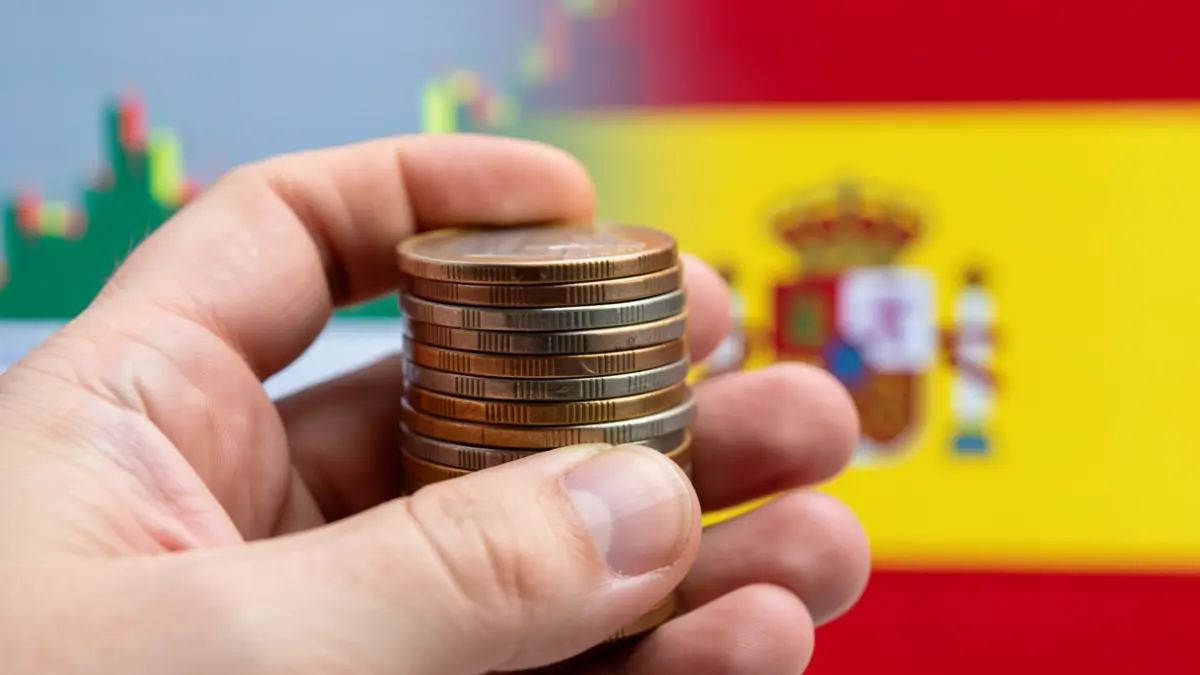 Imagen genérica de monedas de euro y un gráfico financiero con motivos andaluces.