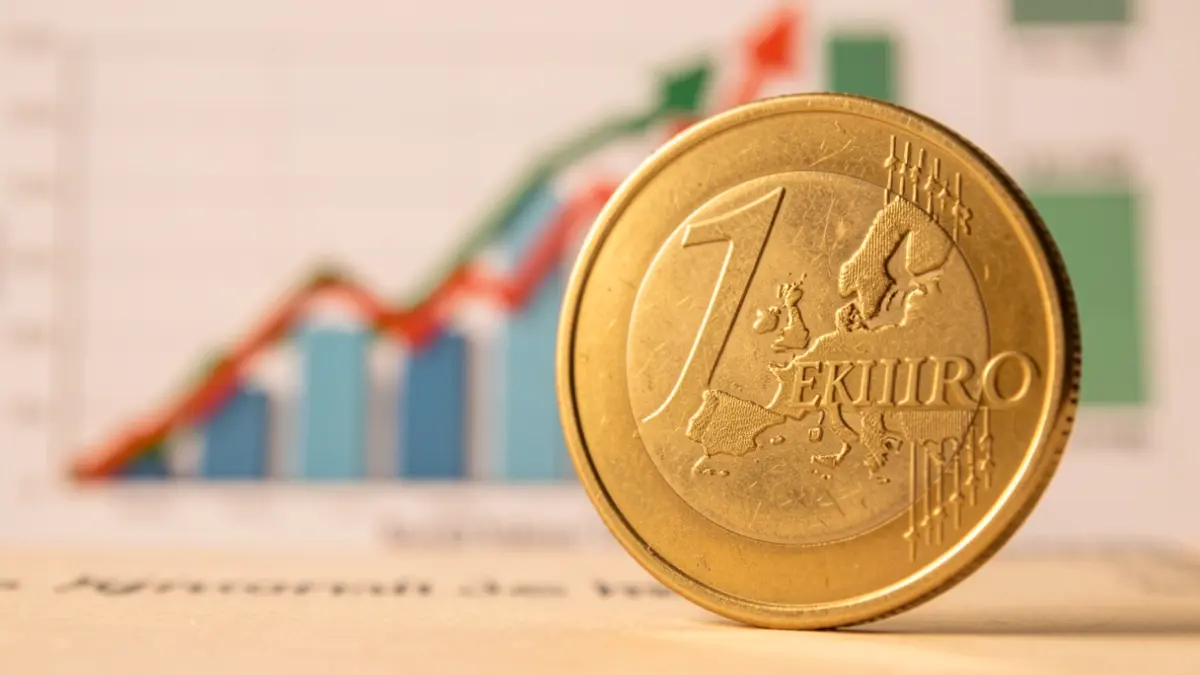 Close-up of a Spanish euro coin with an upward inflation graph in the background.