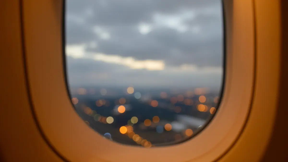 Generic image of a cloudy sky seen from an airplane window.