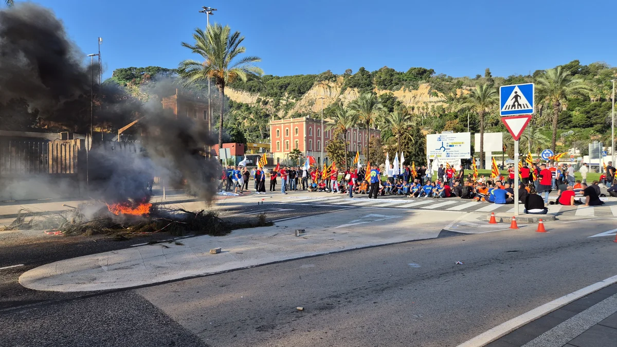 Trabajadores de la Autoridad Portuaria de Barcelona concentrados en una rotonda del puerto, junto a una hoguera, durante la protesta de este miércoles.